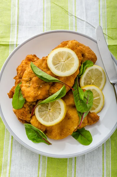 Fried schnitzel with herbs and lemon — Stock Photo, Image