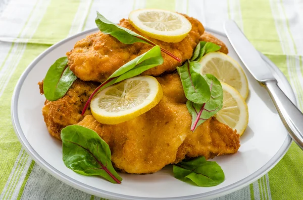 Fried schnitzel with herbs and lemon — Stock Photo, Image