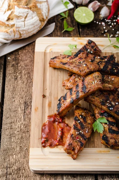 Grilled Spareribs in spicy marinade with beer and rustic bread — Stock Photo, Image