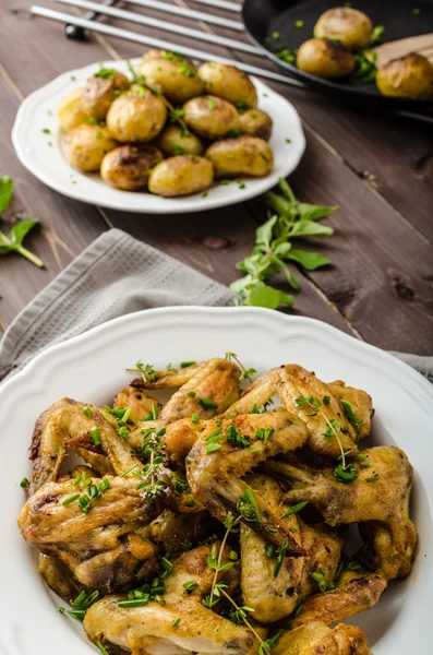 Ailes de poulet rôties avec pommes de terre neuves — Photo