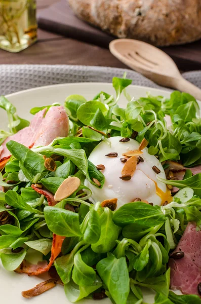 Veldsla salade met gepocheerd ei en noten — Stockfoto