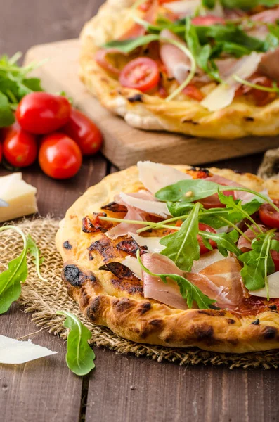Pizza italiana con queso parmesano, jamón y rúcula —  Fotos de Stock