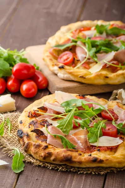 Pizza italiana con queso parmesano, jamón y rúcula —  Fotos de Stock
