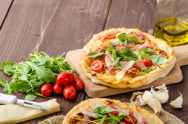Włoska pizza z serem parmezan, szynka i rukoli — Zdjęcie stockowe
