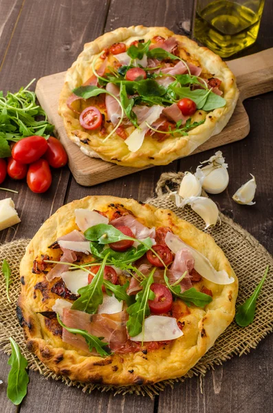 Pizza italiana com queijo parmesão, presunto e rúcula — Fotografia de Stock