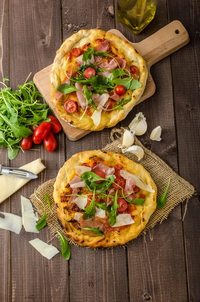Итальянская пицца с сыром пармезан, прошутто и ругулой — стоковое фото