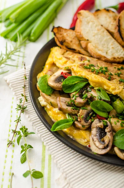 Omelet with mushrooms, lambs lettuce, herbs and chilli — Stock Photo, Image