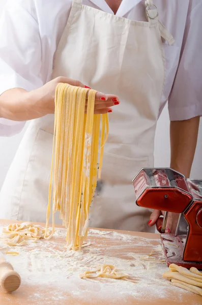 Young woman chef prepares homemade pasta