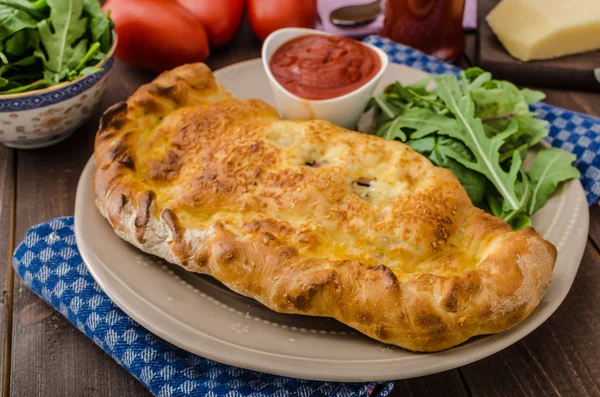 Пицца Calzone с сыром и прошутто — стоковое фото