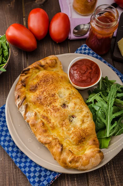 Пицца Calzone с сыром и прошутто — стоковое фото