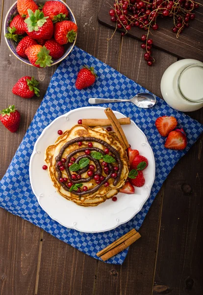 Cinnamon pancakes with chocolate sauce and berries — Stock Photo, Image