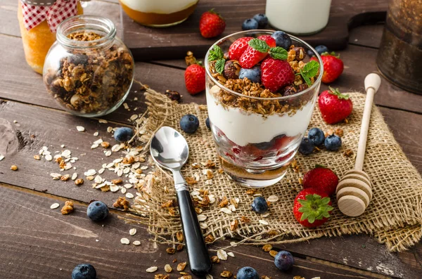 Jogurt s pečené müsli a ovocem v malé skleněné — Stock fotografie