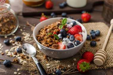 Pişmiş granola ve meyveleri küçük kase yoğurt