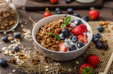 Pişmiş granola ve meyveleri küçük kase yoğurt