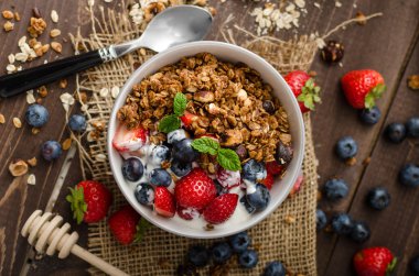 Pişmiş granola ve meyveleri küçük kase yoğurt