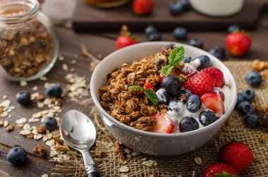 Pişmiş granola ve meyveleri küçük kase yoğurt