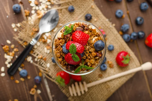 Yoghurt met gebakken muesli en bessen in kleine glazen — Stockfoto