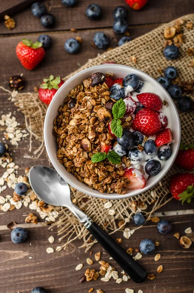 Yogur con granola al horno y bayas en un tazón pequeño — Foto de Stock