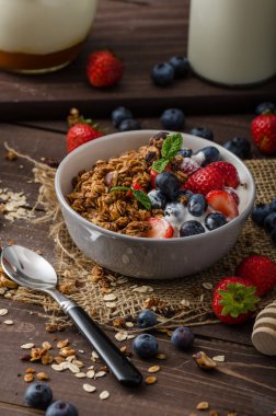 Pişmiş granola ve meyveleri küçük kase yoğurt