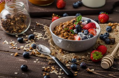 Pişmiş granola ve meyveleri küçük kase yoğurt