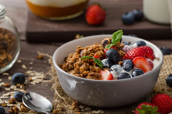 Yoghurt med bakad granola och bär i liten skål — Stockfoto