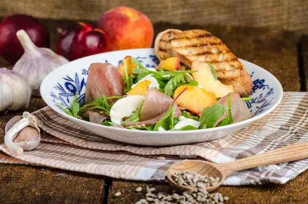 Rocket salad with prosciutto and fruit
