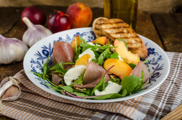 Rocket salad with prosciutto and fruit — Stock Photo, Image