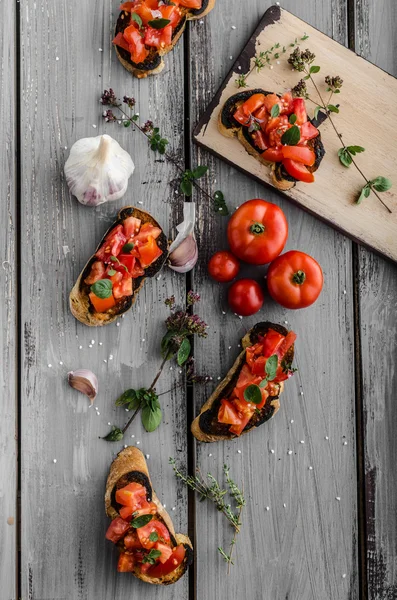 Bruschetta with tomatoes, garlic and herbs — Stock Photo, Image