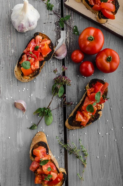 Bruschetta with tomatoes, garlic and herbs — Stock Photo, Image