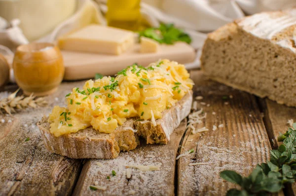 Scrambled eggs on homemade bread — Stock Photo, Image