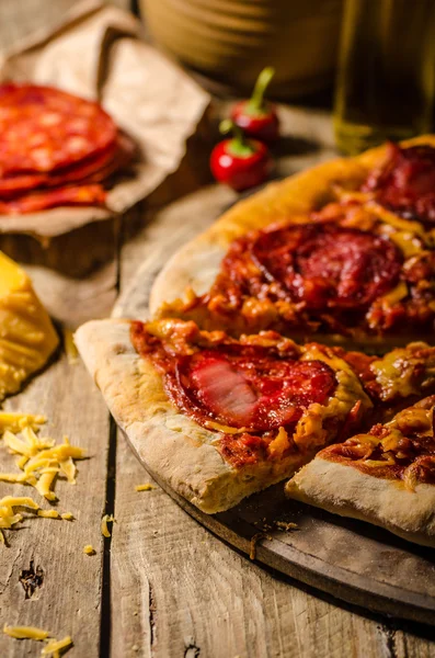 Pizza z salami rustykalny z serem cheddar i chorizo — Zdjęcie stockowe