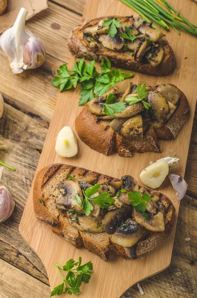 Mushroom mixture on rustic toast with garlic — Stock Photo, Image