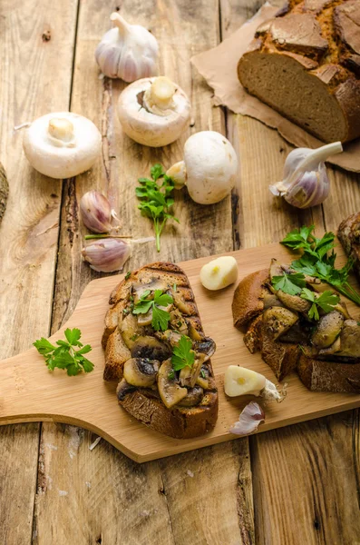 Mezcla de champiñones sobre tostadas rústicas con ajo —  Fotos de Stock