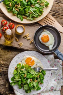 Fried eggs with salad and nuts clipart