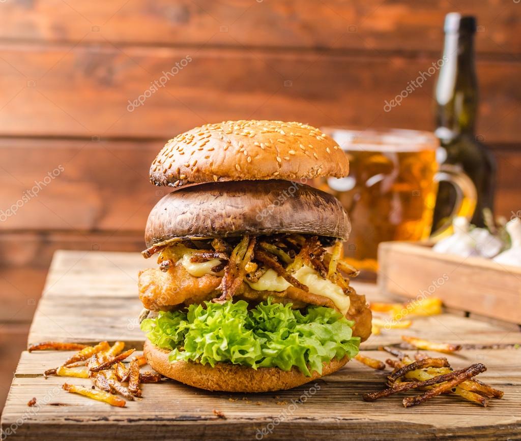 Hamburguesa de pescado y patatas fritas con portobello a la parrilla fotografía de stock