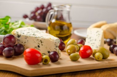 Lezzetli mavi peynir zeytin, üzüm ve salata ile