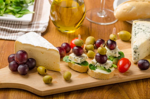 Delicious blue cheese with olives, grapes and salad — Stock Photo, Image