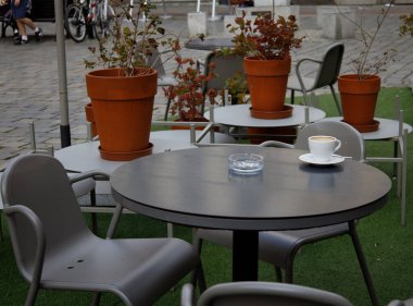 tenha bir kafede boş bir kahve fincanı ve kül tablası.