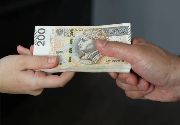 Mano masculina dando un paquete de billetes grandes a manos femeninas — Foto de Stock