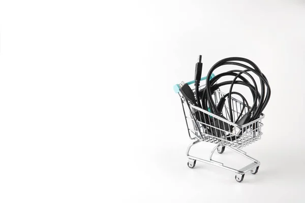 Carrito de compras en miniatura con cables sobre fondo blanco — Foto de Stock