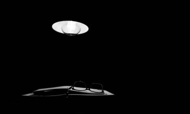 Gece lambanın ışığı deftere düşer ve gözlük okur.