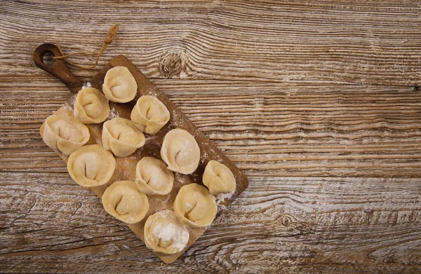 Tahtada, ahşap masada etli börekler.