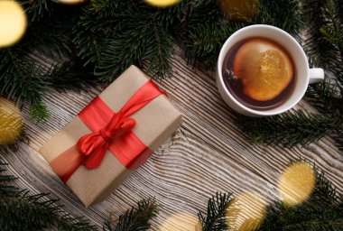 Kırmızı kurdeleli hediye kutusu ve sıcak kokulu bir bardak.