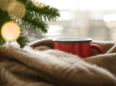 Soğuk bir öğleden sonra kırmızı metal bardakta sıcak bir içecek.