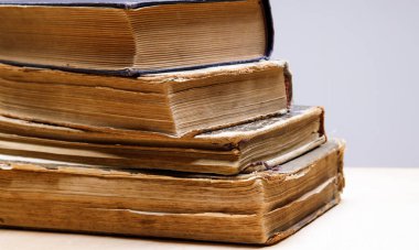 Sıraya dizilmiş birkaç eski ve antika kitabın yakın çekimi. 