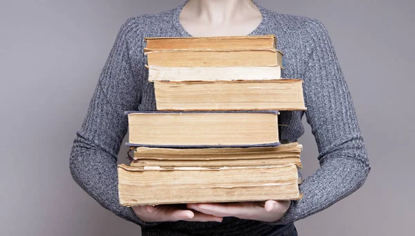 The hands of an invisible person holding many old books — Stock Photo, Image
