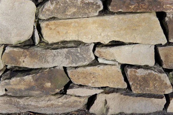 Τοίχος από γκρίζες πέτρες διαφόρων μεγεθών, η υφή της τοιχοποιίας — Φωτογραφία Αρχείου