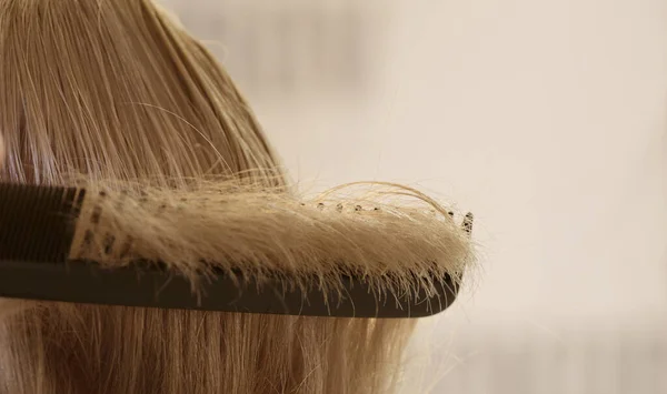 Klientów kosmyk włosów na czarny grzebień fryzjerski — Zdjęcie stockowe