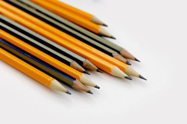 few sharply sharpened pencils of different color on the white table