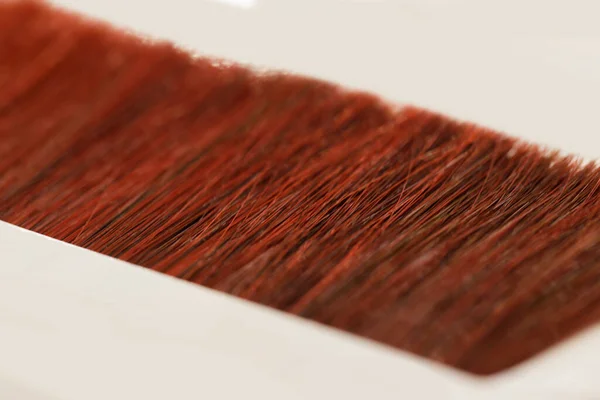 Hair samples in small strands stacked in a line on a white table — Stock Photo, Image